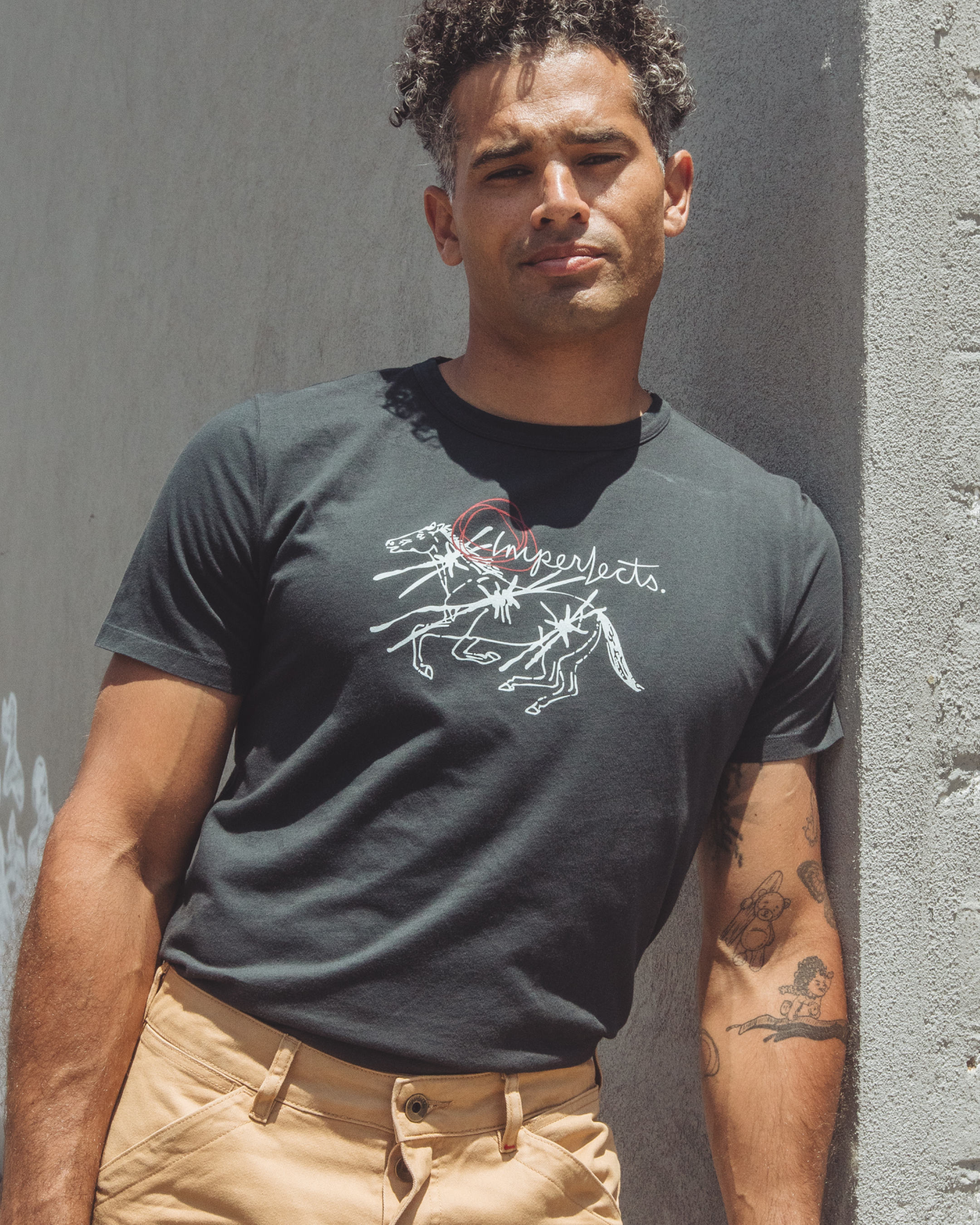 Men’s black organic cotton graphic t-shirt featuring original hand-drawn horse artwork by Tanner Ramsey and “Imperfects” logo, made from 6oz washed single jersey with a soft, broken-in feel.
Thoroughbred T-Shirt in Obsidian.