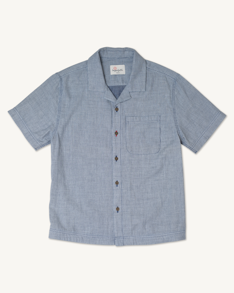 Flat lay of men's Cliffs Camp Shirt in Indigo, featuring soft double-faced cotton fabric, low-profile brass buttons, and a hand-finished hem.
