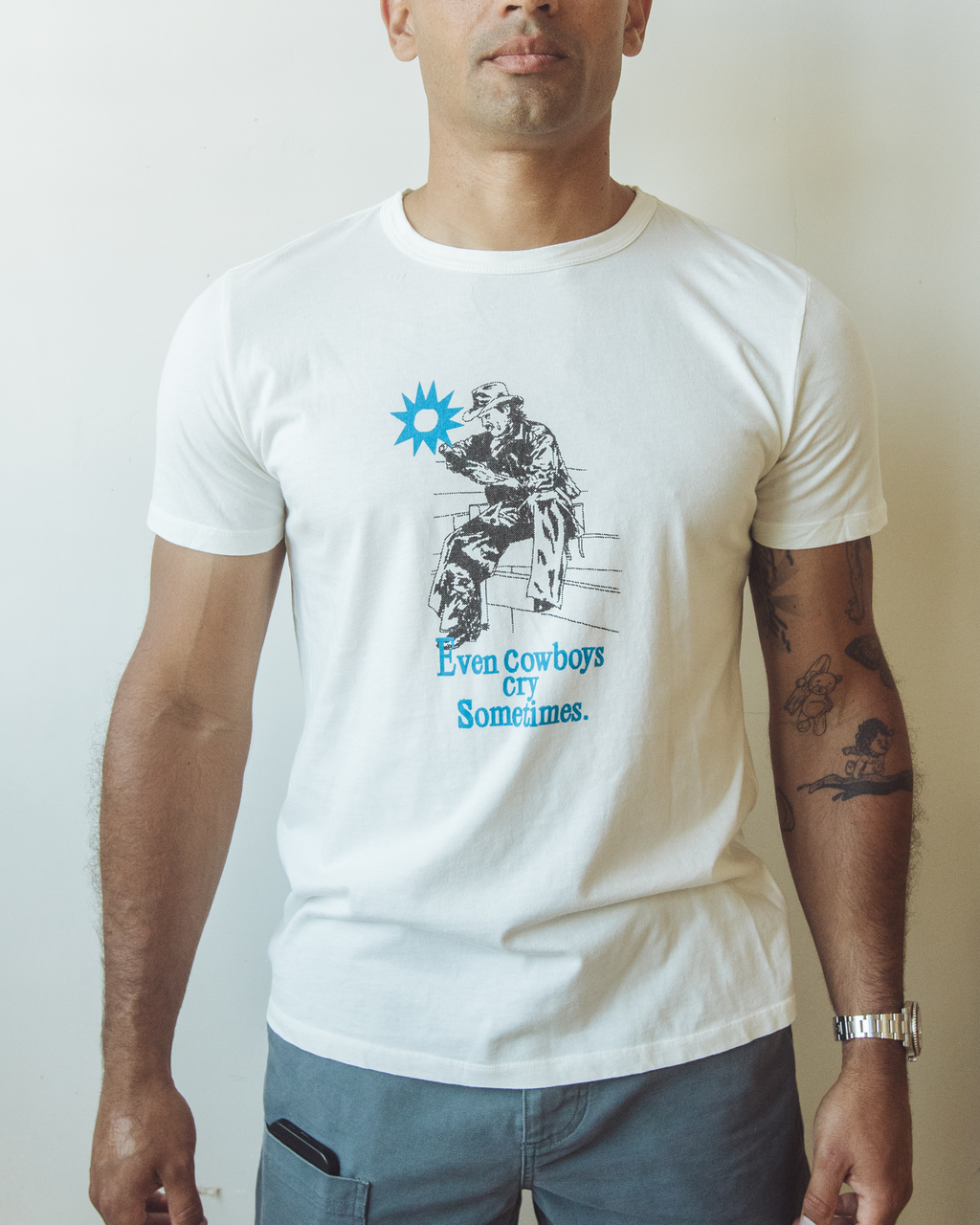Men’s off-white organic cotton t-shirt featuring hand-drawn graphic of a seated cowboy with a blue sun above and the phrase “Even cowboys cry sometimes” printed below.
Old Pals T-Shirt in Half & Half.