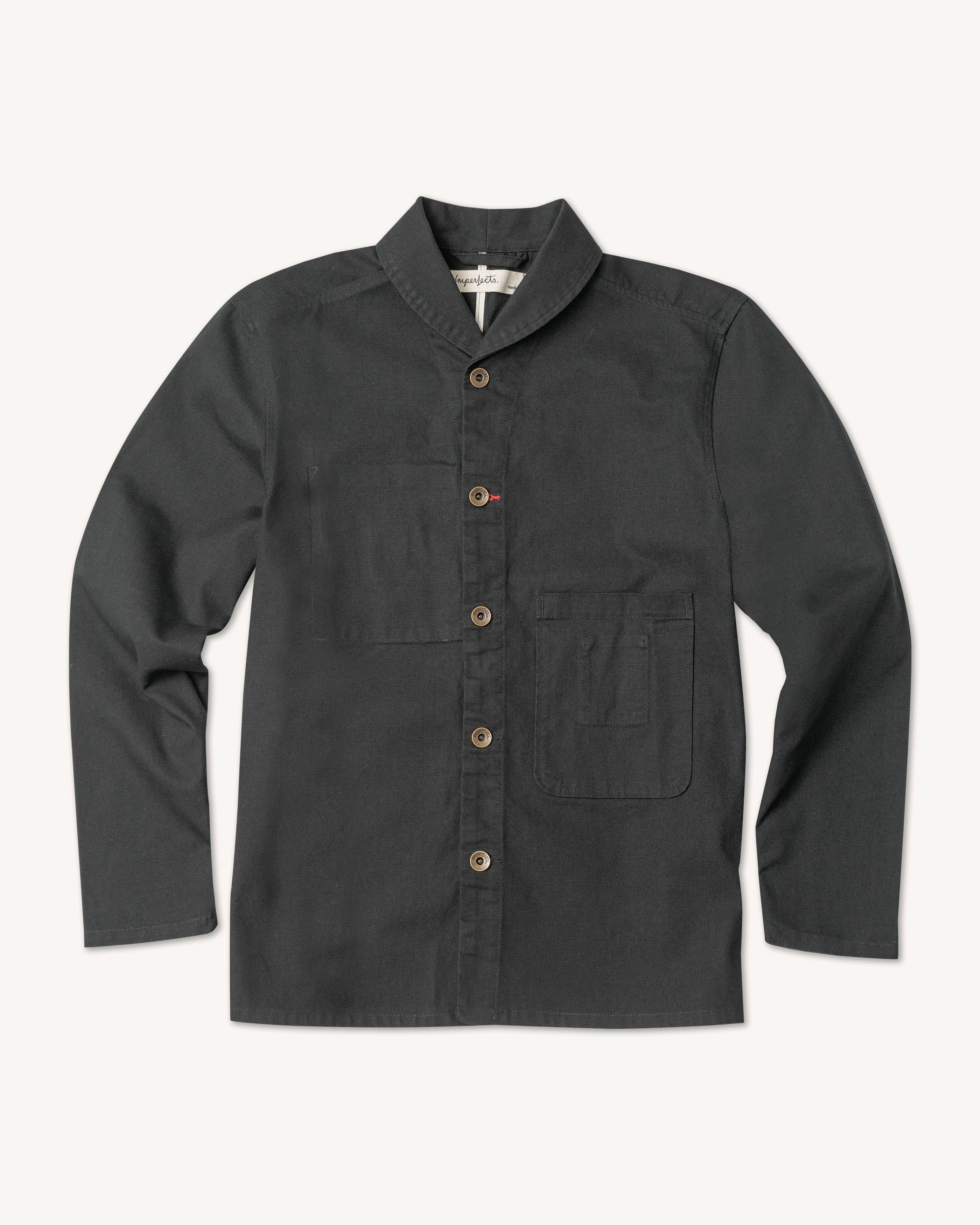 The Shepherds Shirt is a silhouette born of the joining of a family favorite vintage Kimono and a 1920’s French field shirt. This piece has a Kimono style lip collar, French split side seams, and Corozo Buttons. It is finished with a heavy stone wash for effect and comfort and has a refined crop in the sleeves so you can be sure to easily check your timepiece. Obsidian.